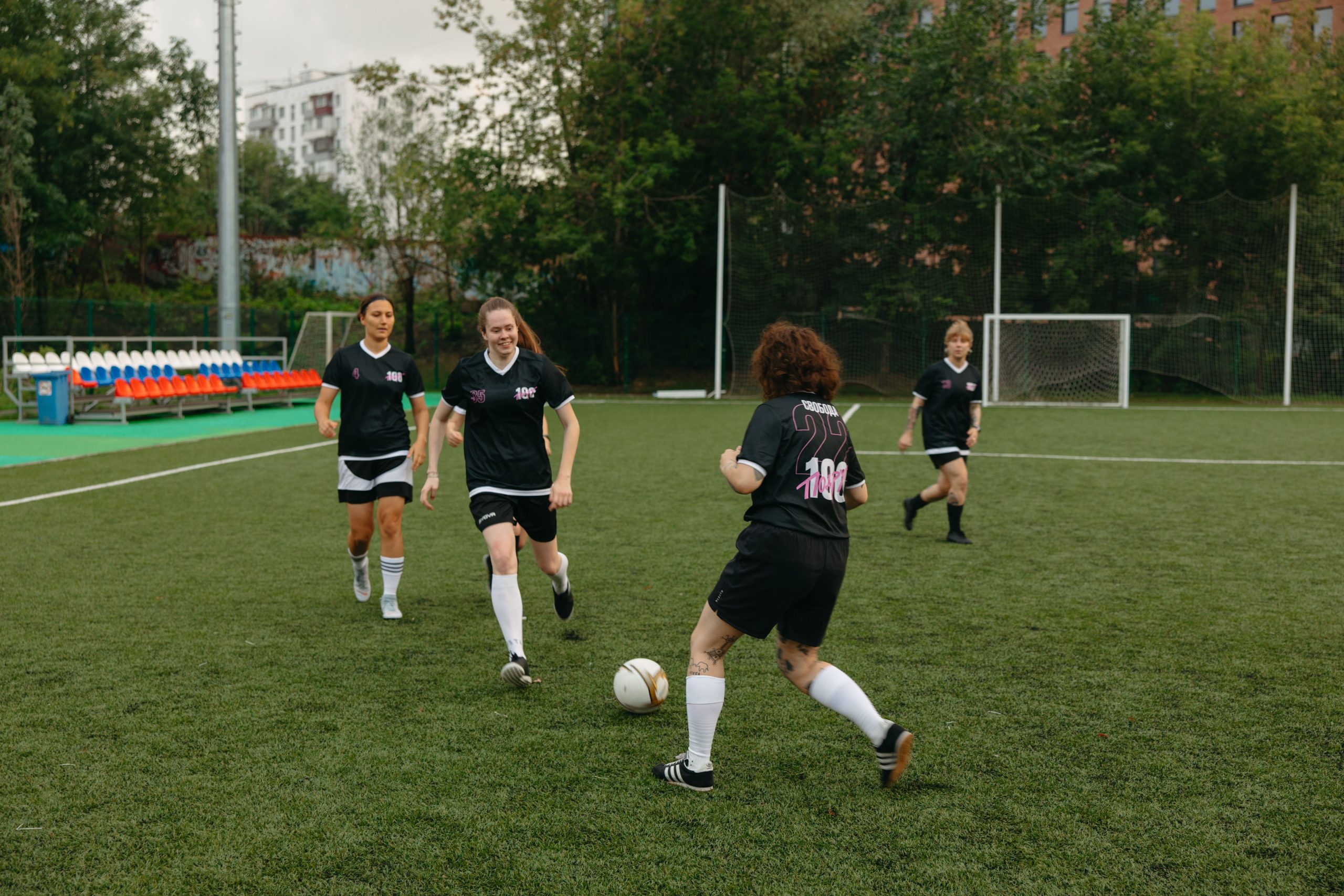 Women soccer players competing on an outdoor field during the day.